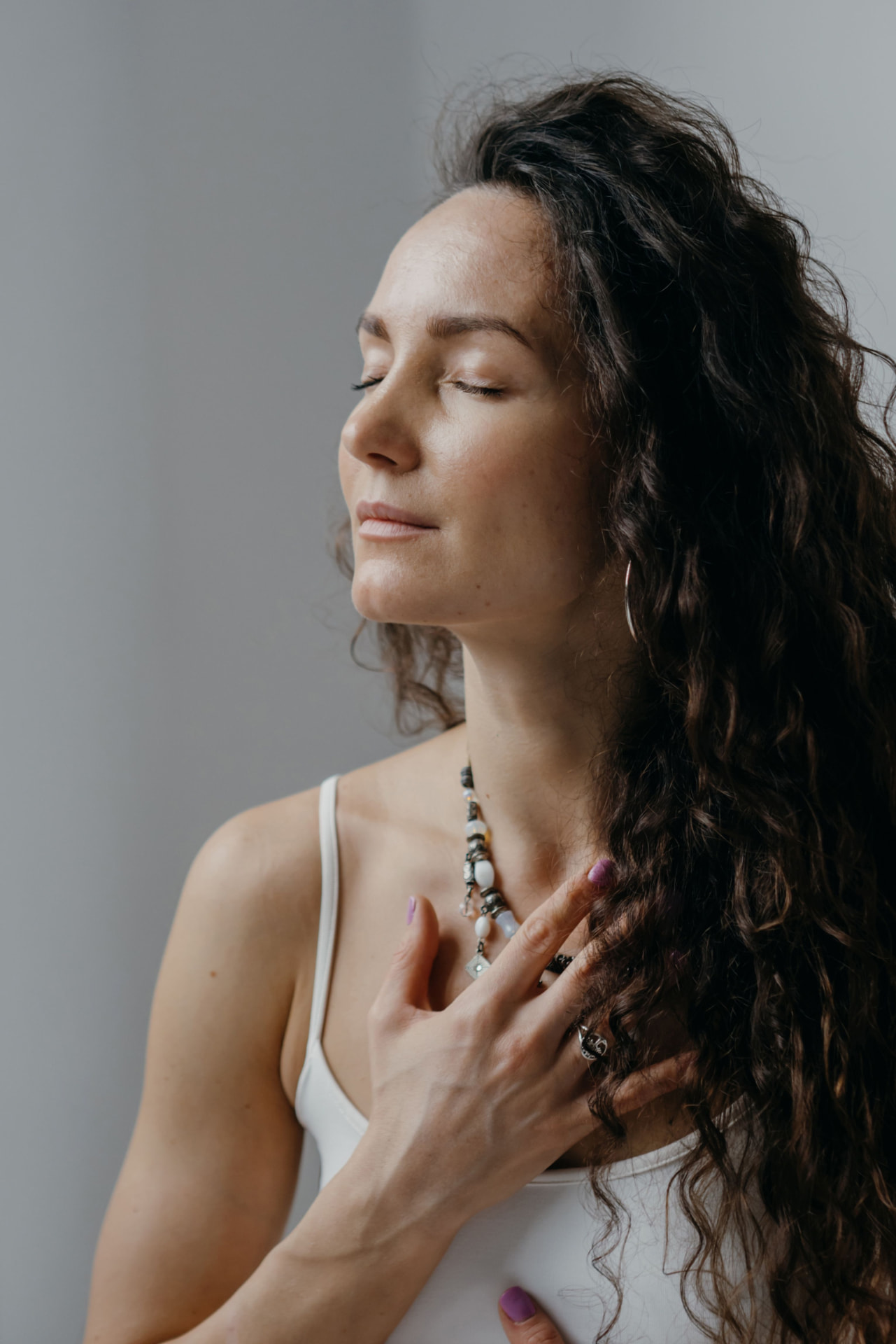 Person taking a calm breath, hand resting on the chest